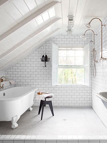 White attic bathroom with pedestal tub 